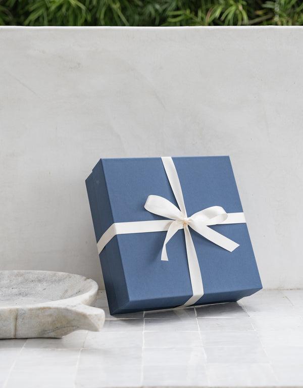 navy gift box displayed against white wall